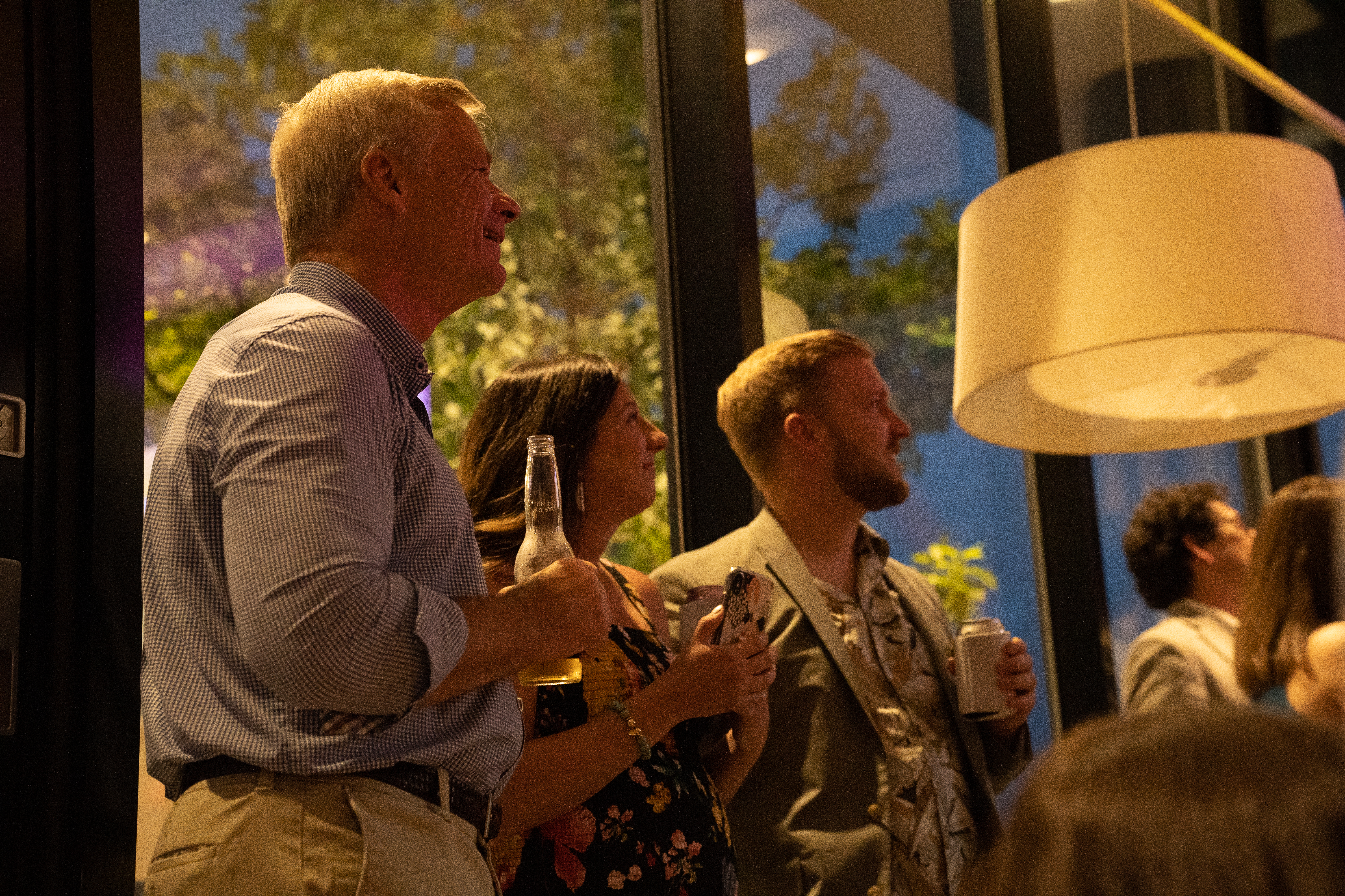 Guests watching the screening with drinks in hand