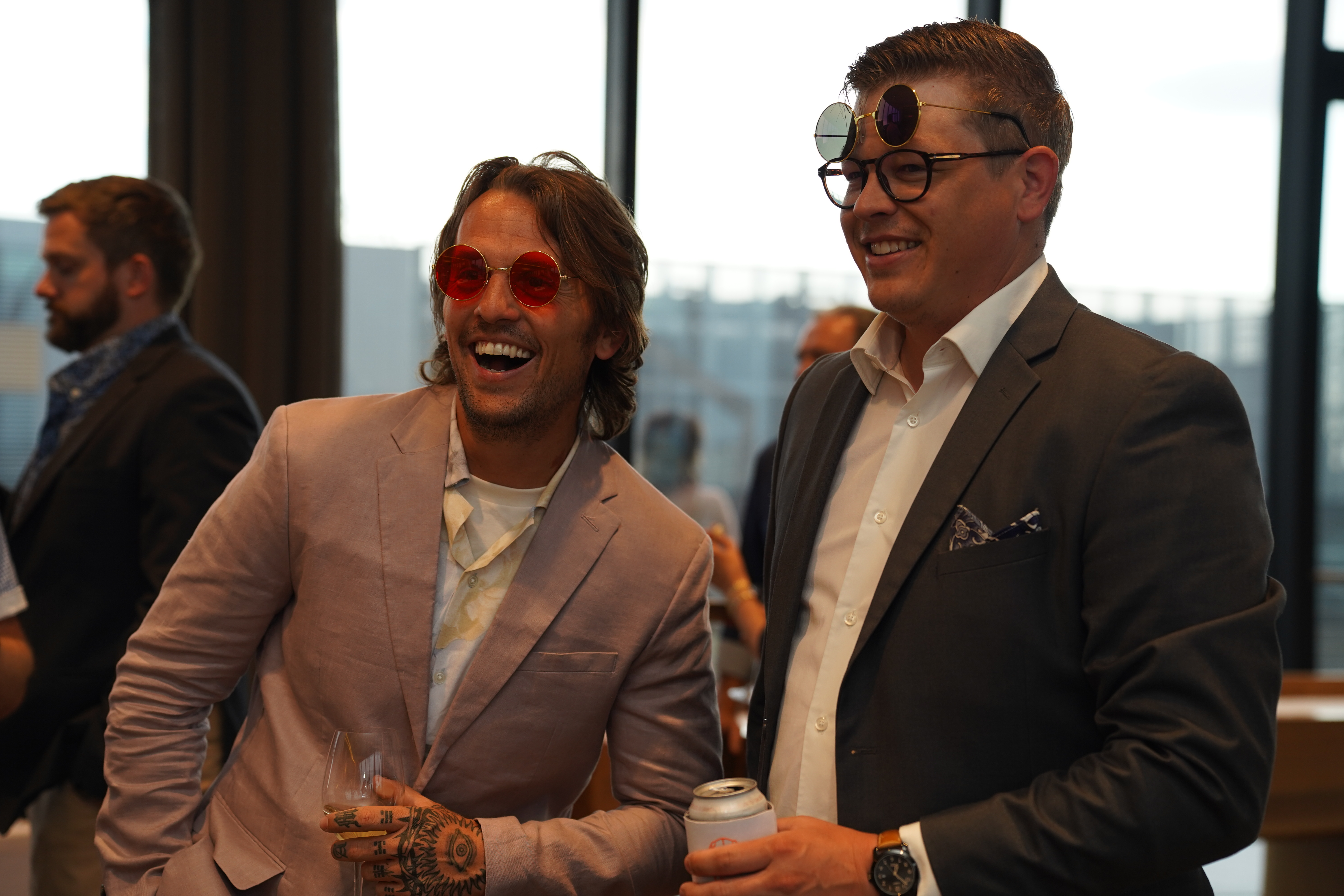 Two guys in suits rocking party sunglasses